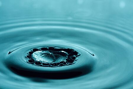 Water drop splashing macro with wavesの写真素材