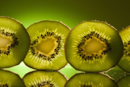 Green Kiwi in row on green backgroundの写真素材
