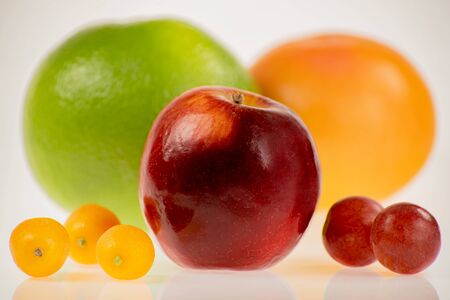 Red apple with other fruits on a white background, intensely colorful and roundの写真素材