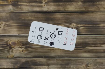 Sheet of a calendar month on a wooden natural backgroundの写真素材