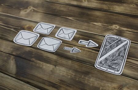 Paper drawn smartphone sketches and letters on wooden