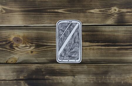Paper sketch of smartphone on wooden backgroundの写真素材