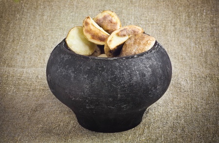 Delicious Baked Potatoes in a Vintage Black Metal Cauldron on a Sacking backgroundの写真素材
