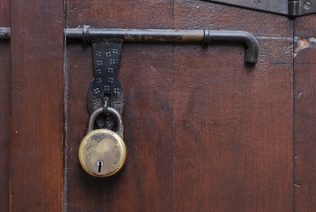 Old padlock, latch and padlock fittings on a wooden door.