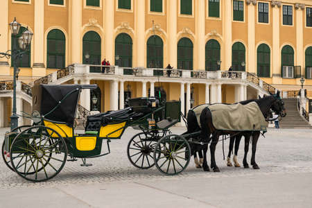 31 May 2019 Vienna, Austria - horse carriages waiting for tourists in front of Schonbrunn Palace. Cloudy morningのeditorial素材