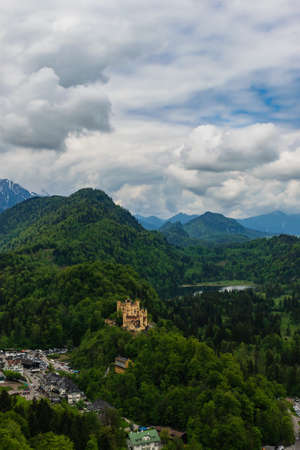 26 May 2019 Fussen, Germany - Hohenschwangau castle among green springtime Alpine mountains. Fussen village, Alpsee and Forggensee lakeのeditorial素材