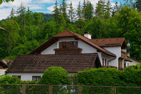 26 May 2019 fussen, Germany - residential district of small town Fussen near Neuschwanstein castle. Small alpine chalets with red tile roofs in mountains. Tidy gardensのeditorial素材
