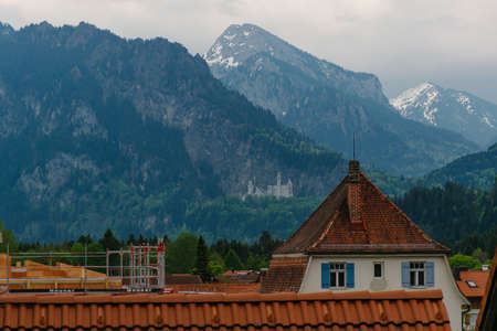 26 May 2019 fussen, Germany - residential district of small town Fussen near Neuschwanstein castle. Small alpine chalets with red tile roofs in mountains. Tidy gardensのeditorial素材