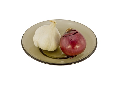 Two onions on a glass plate isolated on whiteの写真素材