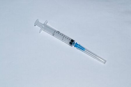 syringe for injection on a white table.の写真素材