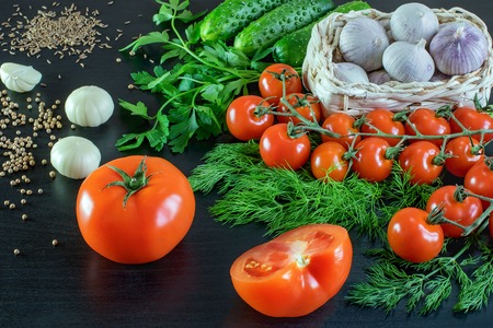 New harvest from the garden. still-life from fresh raw vegetables: tomatoes, cucumbers, garlic, greensの写真素材