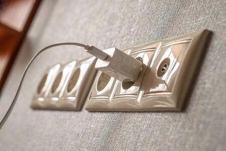 several household electrical outlets and a connected wire charger