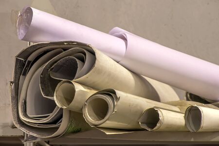 old Whatman wallpaper and paper trash rolled up on a shelf in the dustの写真素材