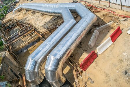 shiny metal pipes on the construction site and installation works pipeline laying