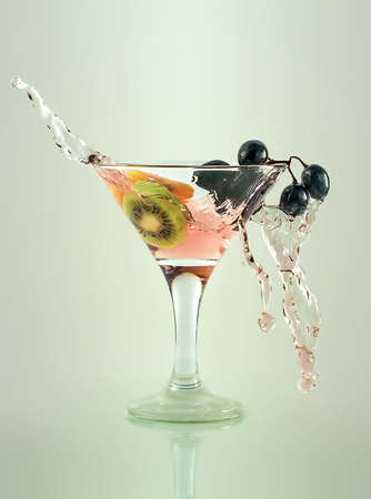 fruit juice with grapes and kiwi in a glass with splashesの写真素材
