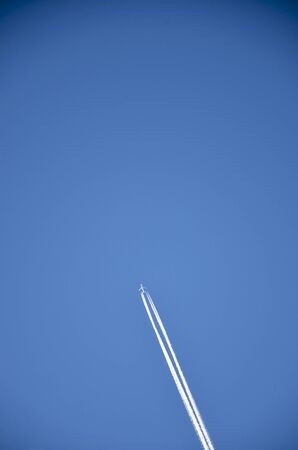 Airplane in sky with trails の写真素材