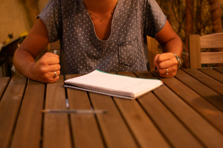 Caucasian teen girl doing her homework with a frustrating expression. Horizontal. With copy-space.