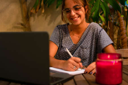 Caucasian teen girl doing her homework with a frustrating expression. Horizontal. With copy-space.の写真素材