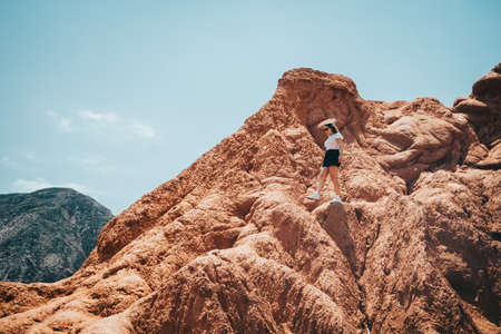 Caucasian woman walking on a peak of a mountain. Horizontal. With copyspace.の写真素材