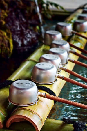 A row of purification ladles in a Japanese templeの写真素材