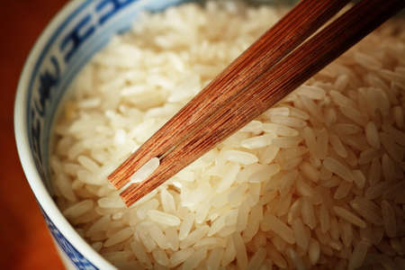 Uncooked rice with chopsticksの写真素材