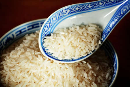 Uncooked rice in spoonの写真素材
