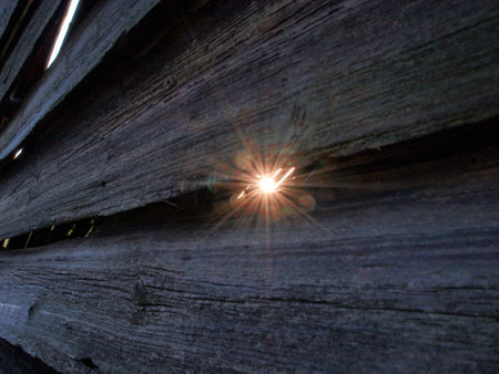 The sun's rays through the cracks in the old boardsの写真素材