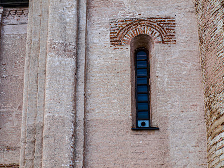 The window is antique in the old brick wall of the churchの写真素材