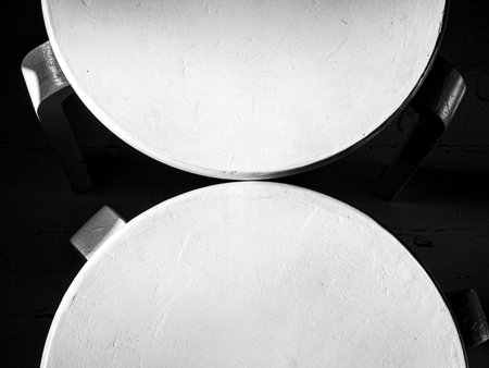 Close up of two old white round chairs on black and white background