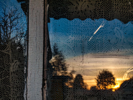 A view through the window of a house at sunset in winter.