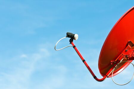 red satellite dish with blue sky の写真素材