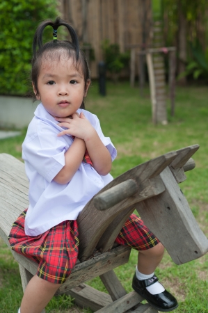 Little girl riding on wooden horseの写真素材