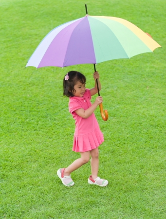 Little girl holding colorful umbrellaの写真素材