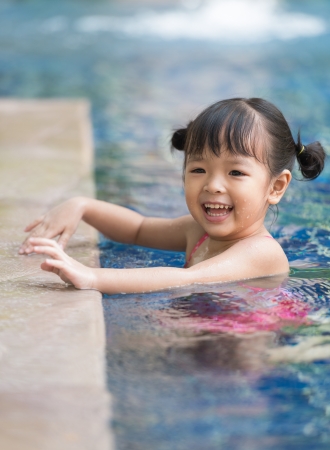 little girl playing in swimming poolの写真素材