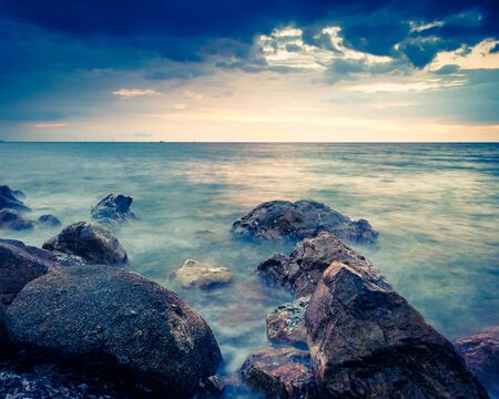 Landscape photo of rocks in the sea in sunset - retro vintage filter effect