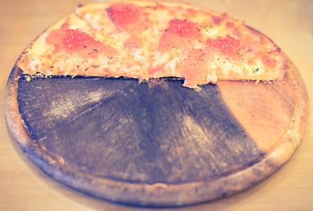 Pizza with smoked salmon and red salted caviar, retro vintage filter effectの写真素材