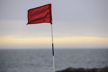 Waving red golf flagの写真素材
