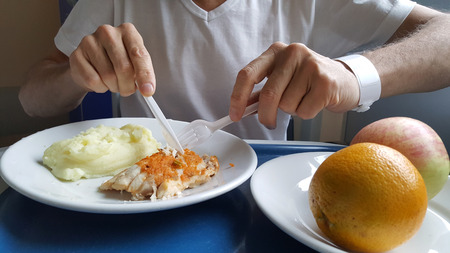 Man in hospital from eating salmon tray of foodの写真素材