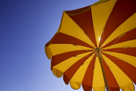 Cropped parasol against clear blue skyの写真素材