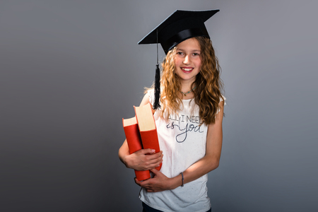Portrait of a beautiful smiling graduate student with booksの写真素材