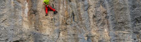 Rock climber climbing on the cliffs of Baunei, est coast of Sardinia, Italyの写真素材