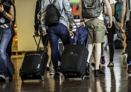 Travelers with suitcases walking through the airportの写真素材