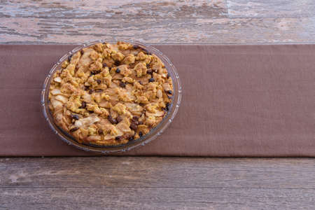 Homemade pie with crumble on a wooden table. Apple Crumble. Apple pie with crumble on wooden...