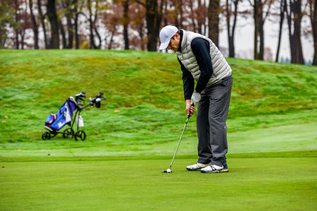 Close-up of a golf player on course aiming for put shot during a tournamentの写真素材