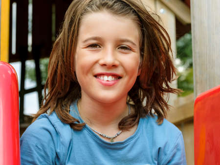 Portrait of a smiling toddler on vacation in an outdoor playground.の写真素材