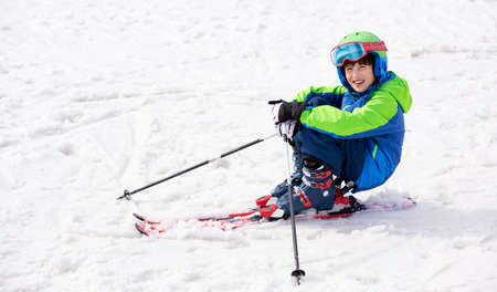 Smiling child on the high altitude ski slope in the Italian Alps. Happy child with helmet and ski goggles on the ski slopes.の写真素材