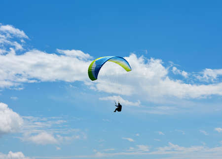 Paraglider that flies from a top of the Intelvi Valley, with a view of the Swiss Alps and Lake Lugano. Concept of lifestyle, freedom and extreme sport adventure.の写真素材