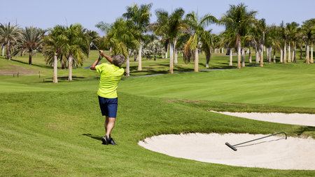 Golfer on a golf course, ready to tee off. Golfer with golf club hitting the ball for the perfect shot.の写真素材