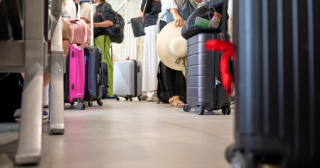People and tourists walk with suitcases waiting for check-in. Tourists ready to board the plane to leave and tourists arrived at destination get off the plane with suitcases in towの写真素材