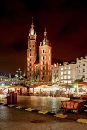 Fantastic view of the Christmas, New Year's Fair in KRAKOW. Main Market Square and St. Mary's Basilica (Church of Our Lady Assumed into Heaven) in the evening.の写真素材